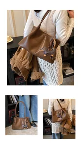 Detailed view of a retro brown leather underarm bag featuring a cute dachshund charm.