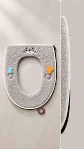 Dettaglio copriwater in peluche grigio con bordi cuciti resistenti.