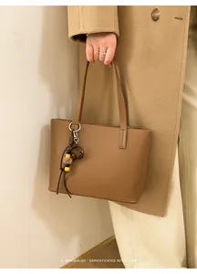 Borsa tote retrò minimalista in pelle marrone con un dettaglio unico di ciondolo con perline