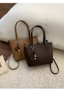 Dettaglio di borse tote retrò marroni e beige con ciondoli decorativi di stile e chic