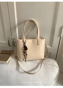 Elegante borsa tote beige minimalista con ciondolo di perline chic in stile retrò.