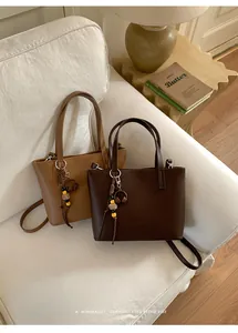 Borse tote vintage minimaliste da donna in marrone e cuoio su un divano bianco