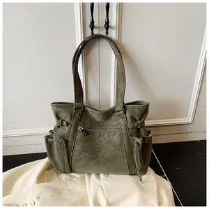 Detalle de un bolso tote grande vintage verde oliva para mujer para uso diario.