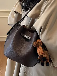 Elegant dark brown textured leather bucket bag with silver buckle and horse plush charm