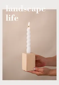 Detail of beige speckled ceramic pillar candle holder held by hands