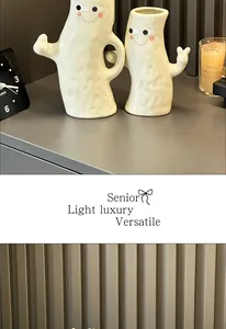 Detail of hand-in-hand white ceramic ghost vases with cute smiley faces