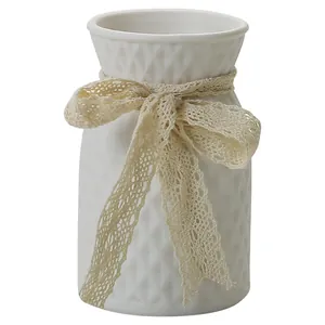 Elegant white ceramic vase with textured diamond pattern and decorative lace bow