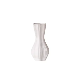 Minimalistische witte geribbelde keramische vaas voor moderne huisdecoratie en bloemen.