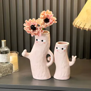 Pair of hand-in-hand pink ceramic vases with cute faces for stylish modern home decor