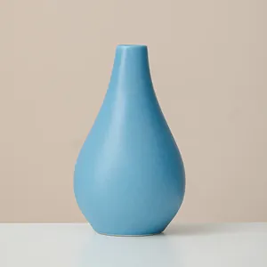 Modern light blue ceramic vase in teardrop shape for minimalist home decor projects