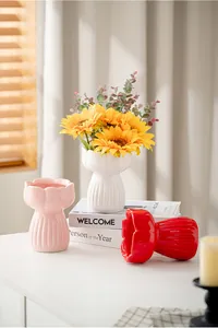 Detail view of decorative ceramic tulip vases in white pink and red with sunflowers