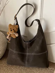 Bolso de hombro vintage marrón oscuro con costuras en contraste y oso de peluche