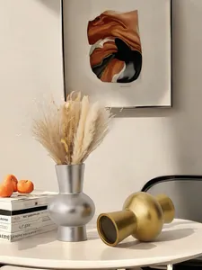 Détail de vases en céramique dorés et argentés dans un intérieur de luxe