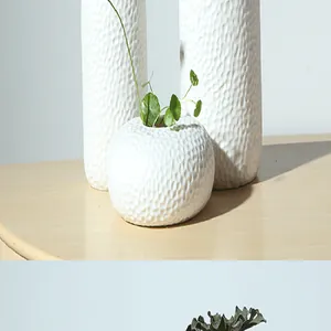 Textuurdetail van handgemaakte witte keramische vaas met plant