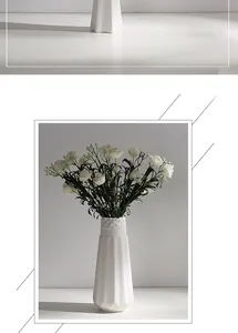 Detailed view of a white ceramic vase with geometric texture and elegant white flowers.