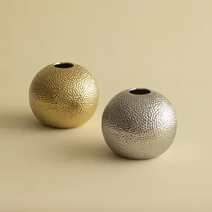 Close-up detail van de luxe gehamerde textuur op gouden en zilveren keramische vazen