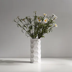 Minimalist white ceramic vase with honeycomb texture and artificial daisies for home decor