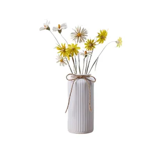Elegant white ribbed ceramic vase with artificial flowers for minimalist home table decor