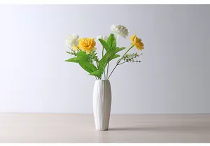 Modern white ceramic vase with yellow and white artificial flowers for home decor