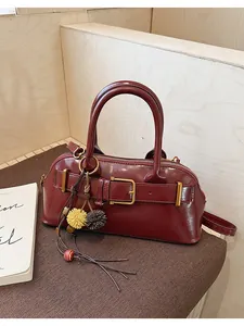 Vista dettagliata di una borsa a mano retrò bordeaux a conchiglia con fibbia e ciondoli