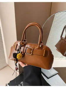 Vista dettagliata della borsa a conchiglia marrone vintage con fibbia e ciondoli