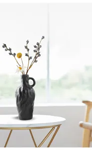 Vase en céramique noire moderne avec texture ondulée irrégulière et petite poignée