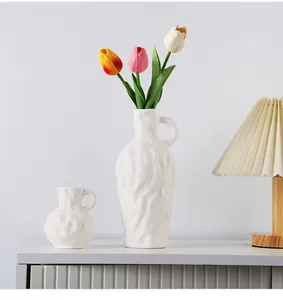 Deux vases en céramique blanche minimalistes avec tulipes pour décoration d'intérieur