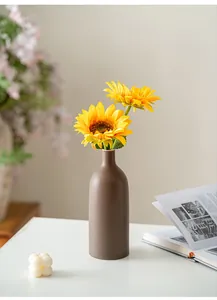 Detailansicht einer braunen matten Morandi-Keramikvase mit minimalistischem Sonnenblumen-Dekor
