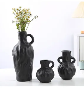Vue détaillée de trois vases en céramique texturée noir mat au style minimaliste