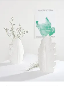 Minimalist white ceramic vase in a leaf shape with elegant dried flowers for decor