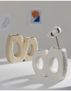 Detailed view of white and cream textured ceramic vases in a minimalist Nordic style room