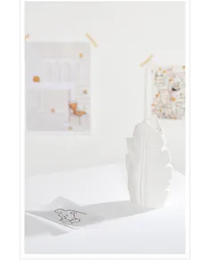 Detailed view of a white leaf-shaped ceramic vase with elegant textured patterns.