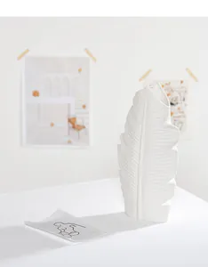 Close-up view showing the detailed texture of a white ceramic banana leaf shaped vase