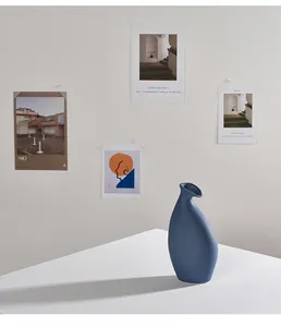 Seitenansicht einer mediterran blauen Keramikvase auf weißem minimalistischem Tisch