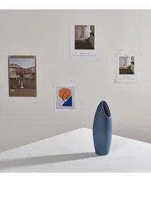 Moderne mattblaue Keramikvase für Trockenblumen in einer minimalistischen Wohndekoration