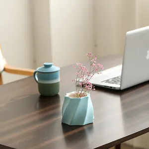 Moderne hellblaue Keramikvase mit Spiraldesign für Trockenblumen auf dem Schreibtisch