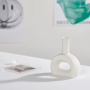 Elegant minimalist white ceramic vase with modern hollow design for chic home decor