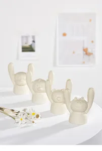 Close-up of adorable ceramic cartoon animal desk card holders in a minimalist setting.