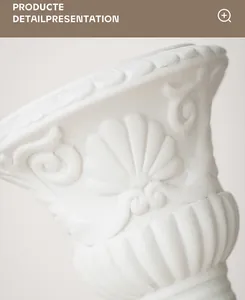Macro detail of a white Roman column vase featuring intricate shell and scroll carvings