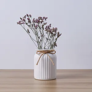 Minimalist white ceramic ribbed vase with twine bow and purple dried flowers