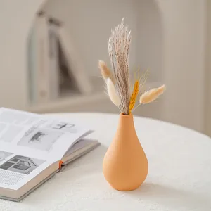Minimalist orange ceramic vase with dried pampas grass for elegant home decoration