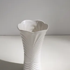 Elegante jarrón minimalista de cerámica blanca con patrón de hojas y borde ondulado