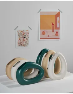 Modern minimalist hollow donut ceramic vases in white, teal, and beige for home decor