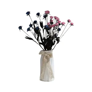 Vase élégant en céramique blanche avec roses roses et bleues et nœud en dentelle décor.