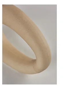 Macro detail of beige ceramic vase showing matte sandy texture and smooth curve.