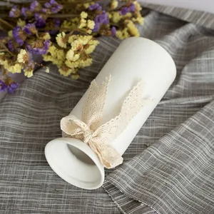 Elegant white ceramic flower vase with a delicate lace bow decoration for modern home decor