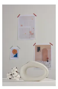 Modern Nordic white ceramic vase with unique hollow design in a minimalist setting.