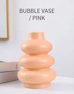 Vista detallada de un moderno jarrón de anillo de cerámica rosa para decoración