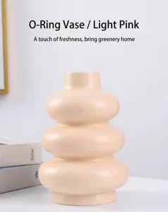 Primer plano de un jarrón de cerámica rosa claro nórdico con un diseño de dona único