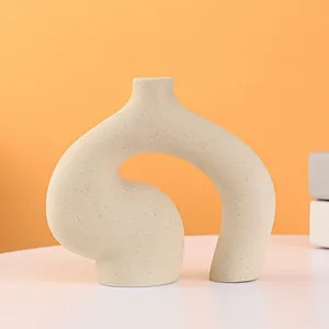 Modern abstract ceramic vase in beige with speckles for home decor centerpiece.